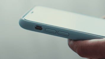 Hand håller i telefon med ljusblått silikonskal